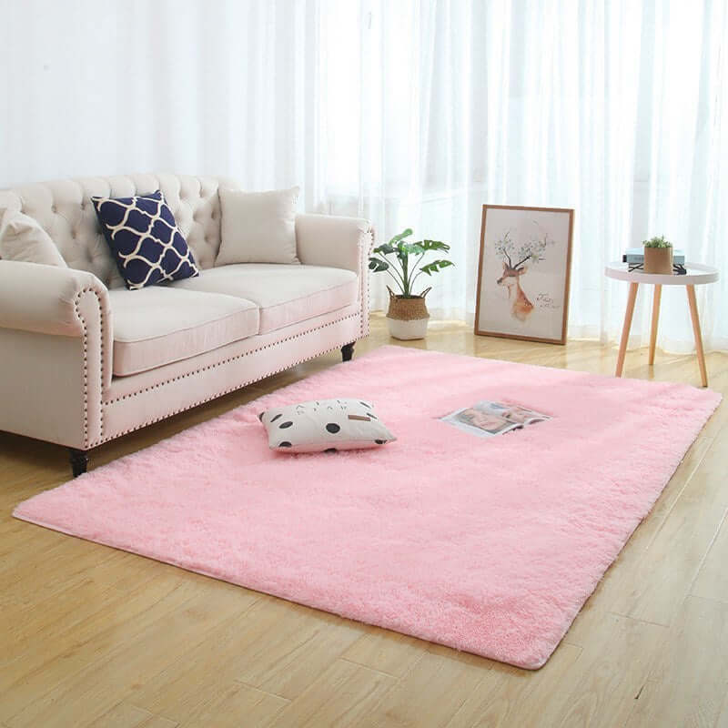 Silky fluffy pink carpet rug in a cozy living room with a sofa and decorative pillow.
