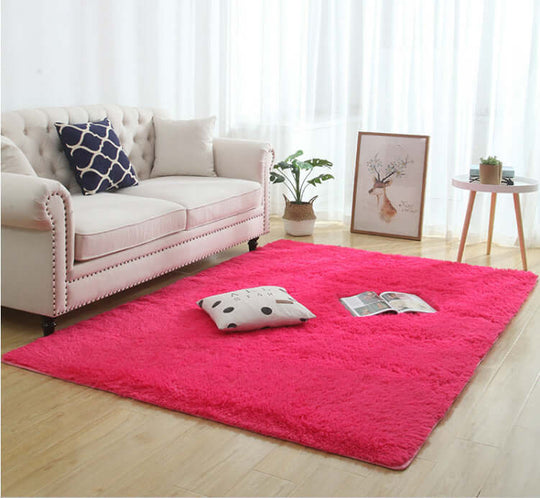 Silky fluffy pink carpet rug in a cozy living room setting with a sofa and decorative pillows.