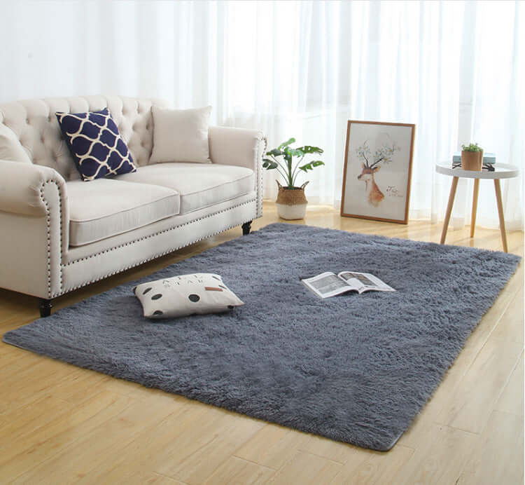 Silky fluffy carpet rug in a cozy living room, featuring machine washable polyester fabric and a calm gray color.