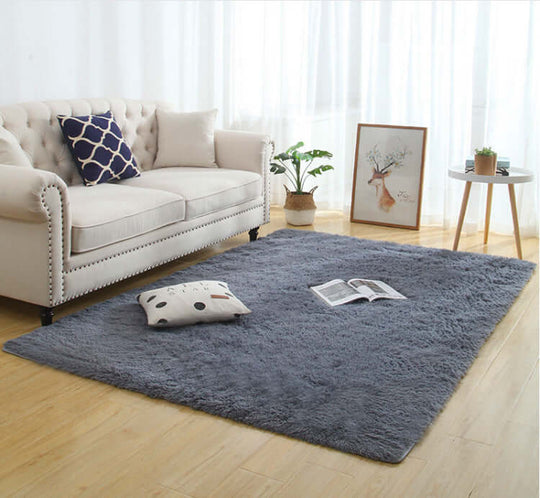 Silky fluffy carpet rug in a cozy living room, featuring machine washable polyester fabric and a calm gray color.