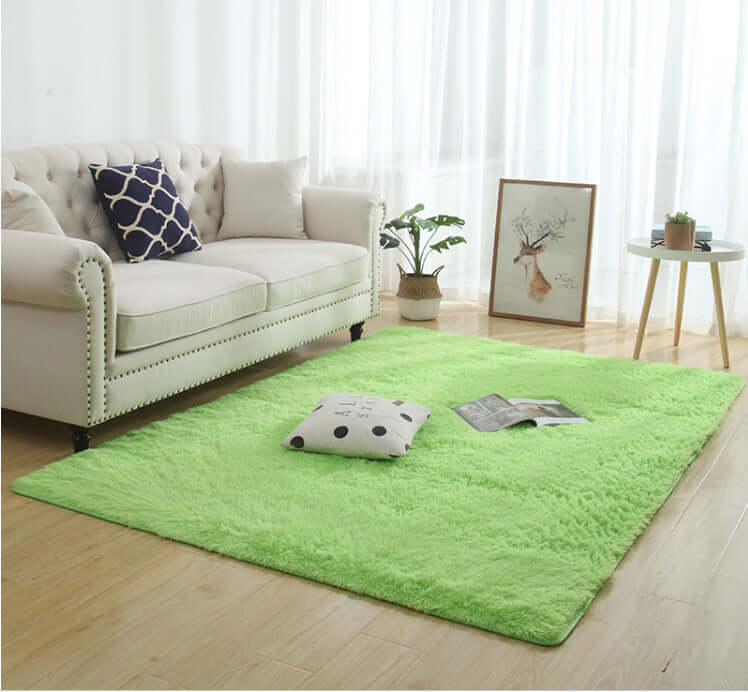 Silky fluffy green carpet rug in a living room with a couch, decorative pillows, and a coffee table.