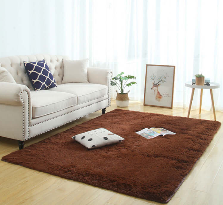 Silky fluffy brown carpet rug in a cozy living room setting with a beige sofa and decorative pillows.