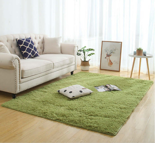 Silky fluffy green carpet rug in a cozy living room setting with a couch and decorative pillows.