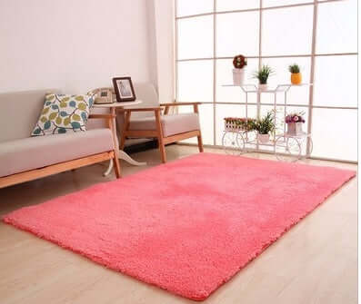 Soft pink solid rug in a cozy living room, perfect for home decoration and comfort.