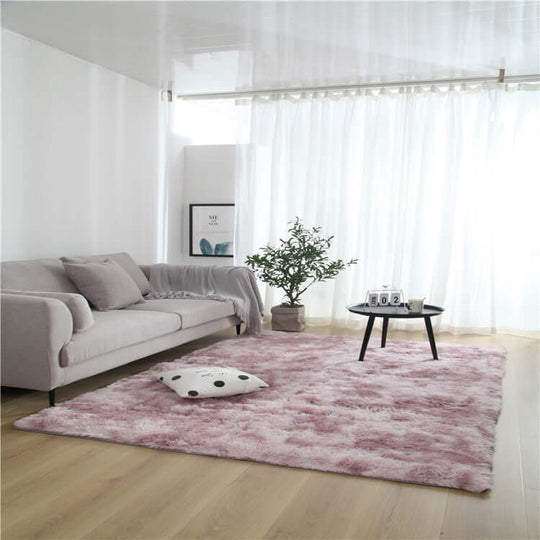 Cozy living room with a pink fuzzy rug, sofa, coffee table, and greenery, showcasing a stylish home decor.