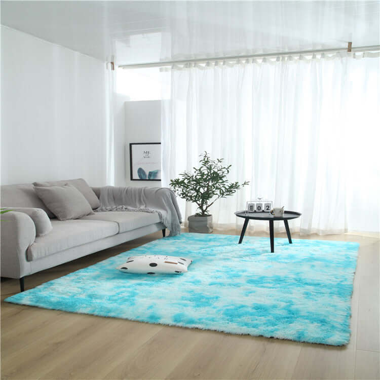 Cozy living room with a soft blue area rug, modern couch, and decorative plant, perfect for enhancing home decor.