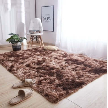 Cozy brown shag rug in a bright living room with a chair and indoor plant, perfect for enhancing home decor.